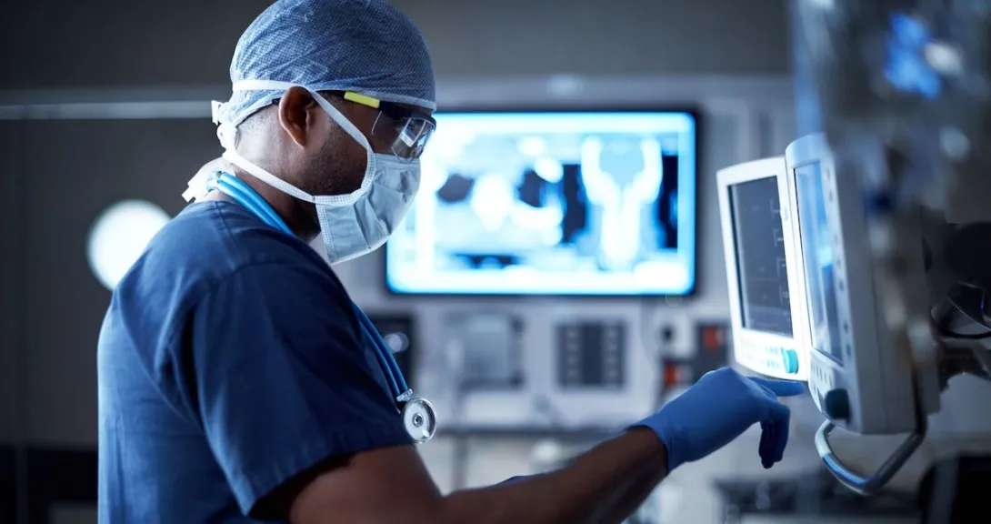   Healthcare provider in scrubs looking at computer screens