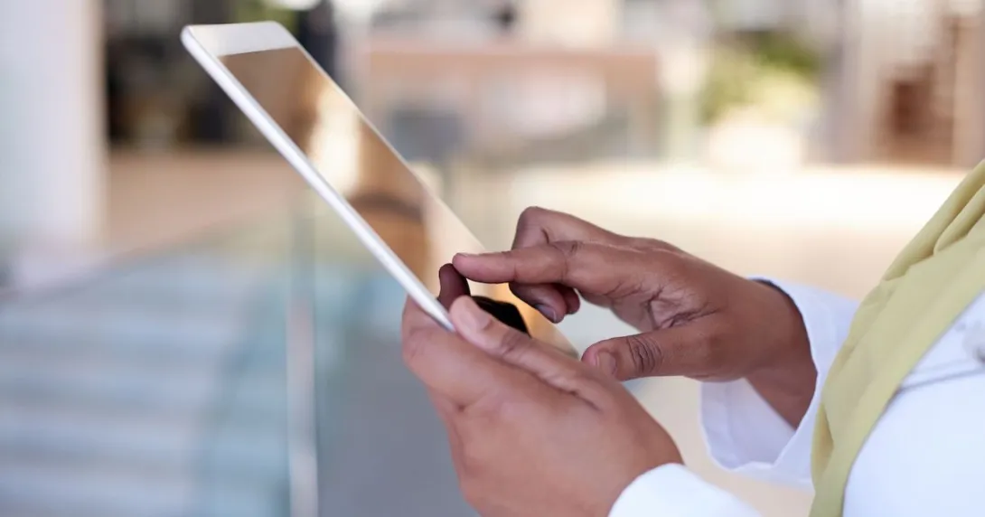 A close up photo of a clinician using a tablet